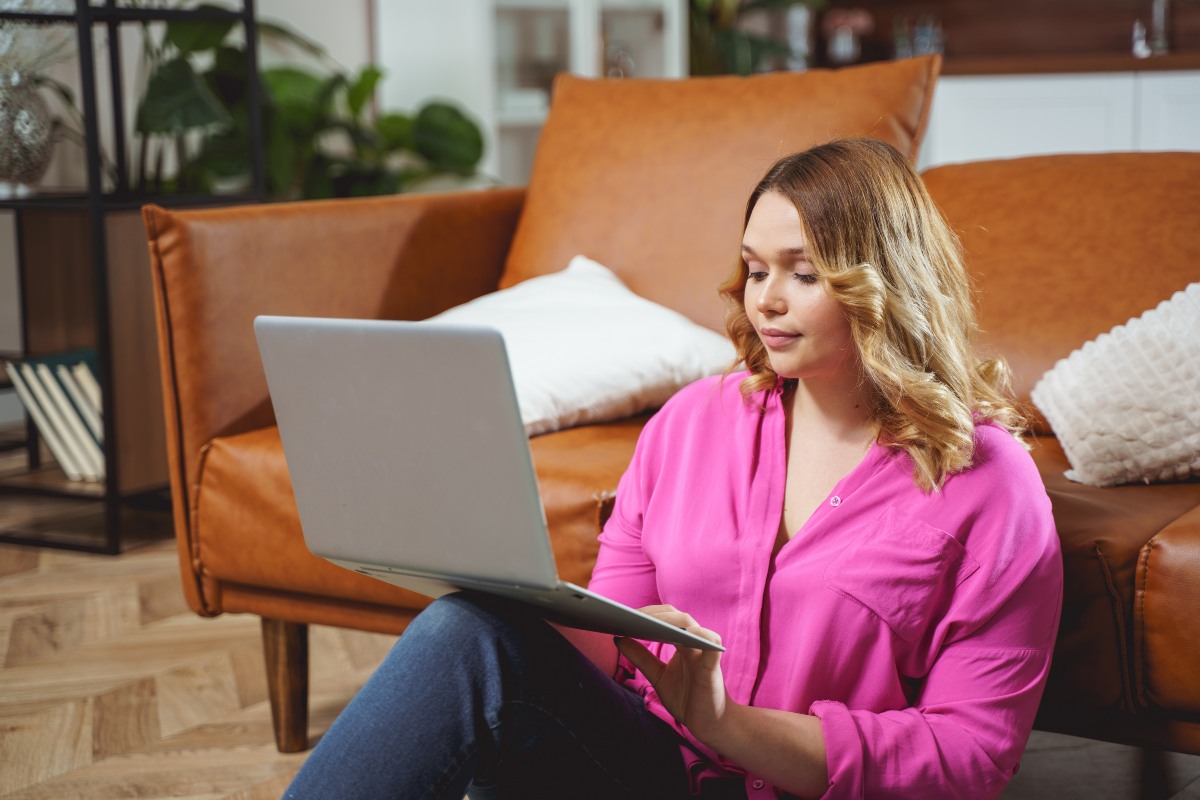 Junge Frau shoppt online mit Laptop