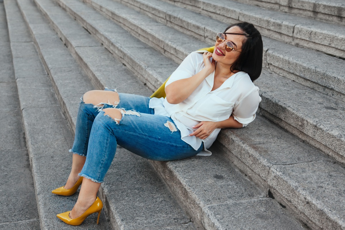 Junge-Frau-Plus-Size-in-Jeans-sitzt-auf-Treppe