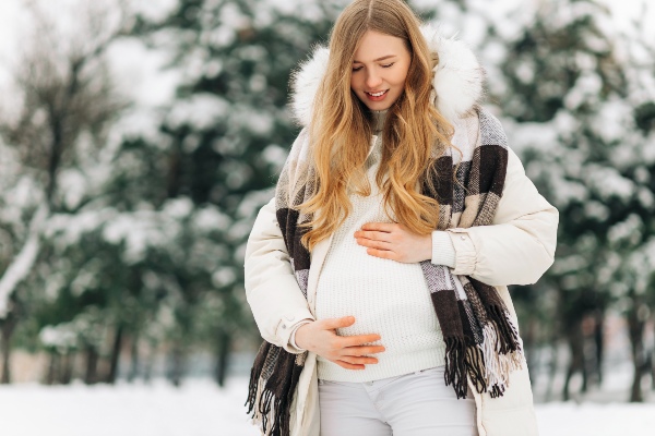 Schwangere-Frau-im-Schnee - Schwangerschafts-Outfit im Winter