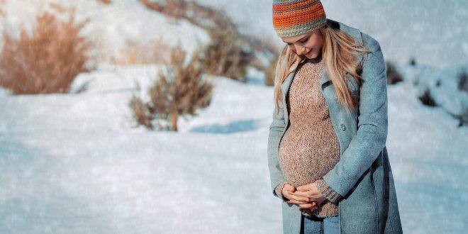 Schwangere-Frau-im-Schnee - Schwangerschafts-Outfit im Winter